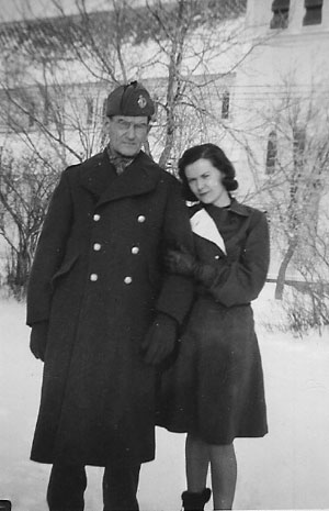 Pte. Patrick J. Hennessy, age 56, in early December, 1940, shortly before he left for basic training at Valcartier Camp in Quebec. Standing with Patrick outside the family home in Bathurst, New Brunswick, Canada is his youngest daughter Anna Hennessy, . Across the street is the old Holy Family Catholic Church.